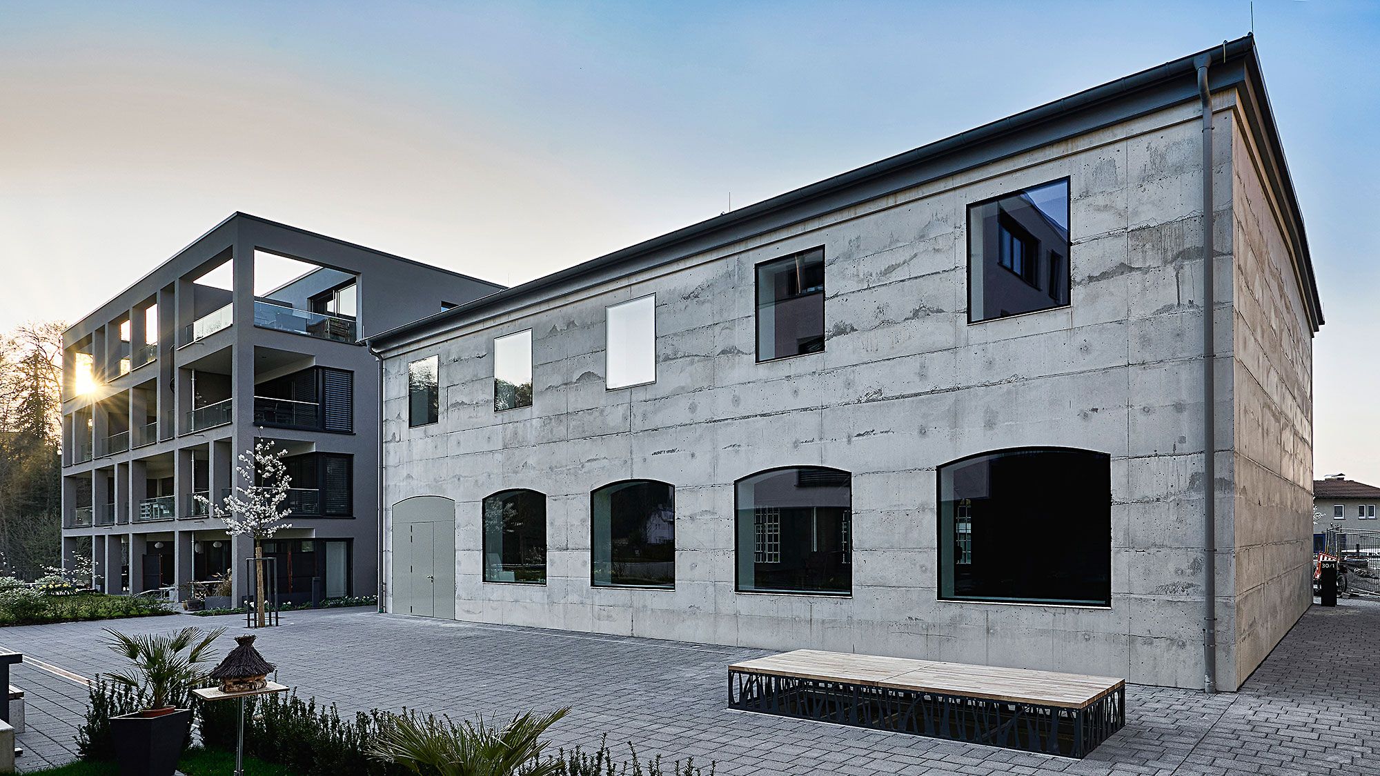 Die rückseitige Sichtbetonfassade zitiert die historische Front und lässt ebenso viel Licht ins Innere